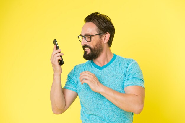 Smartphone de uso alegre hipster Homem usuário feliz do smartphone moderno Fique em contato com o smartphone moderno Junte-se à comunidade online Conceito amigável ao usuário Homem entusiasmado com as oportunidades do telefone celular