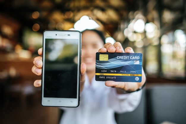 Smartphone e cartão de crédito com mulher na mão