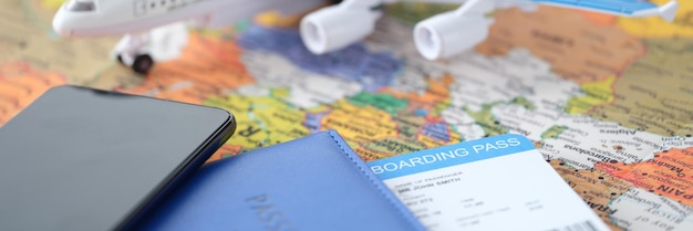 Smartphone e passaporte com bilhetes encontram-se no mapa-múndi com avião pequeno