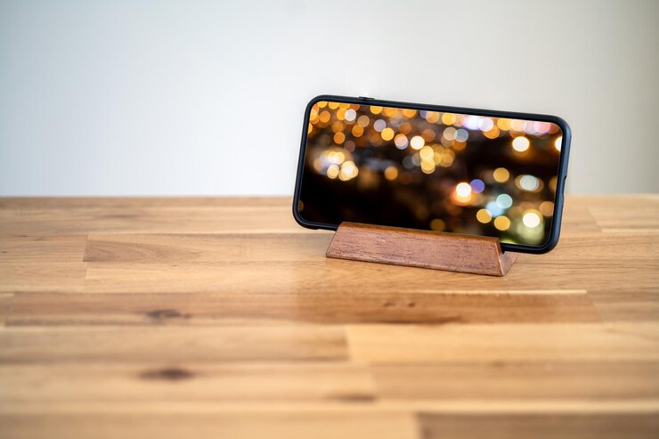Foto smartphone em pé na mesa com maquete de tela desfocada