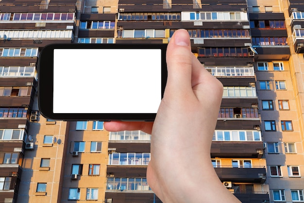 Smartphone y fachada en edificio de apartamentos
