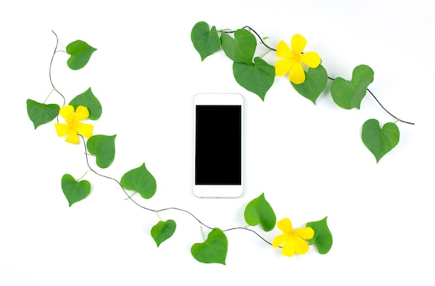 Smartphone con hojas y flores sobre fondo blanco