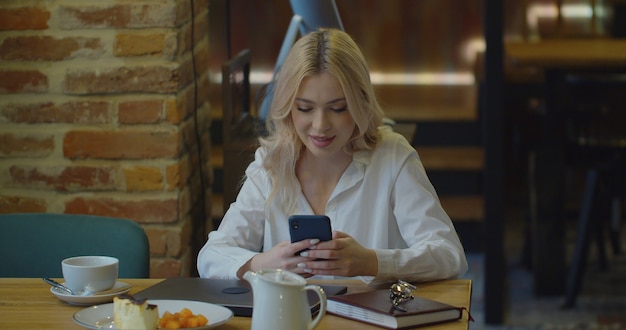 Smartphone in einer weiblichen Hand im Café, mit Handy SMS SMS Browsing-Website.