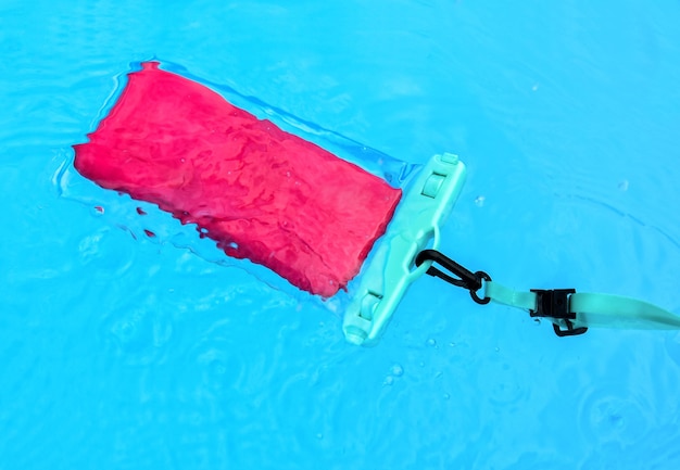 Smartphone in wasserdichter Hülle im Pool