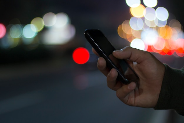 Smartphone con luces de la ciudad en segundo plano, mensajes de texto