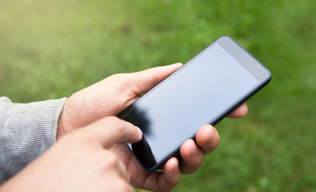 Smartphone en la mano de un hombre al aire libre. El dedo toca la pantalla. Compras en línea, comunicación, redes sociales, gps, mapas, correspondencia, concepto de retroalimentación.