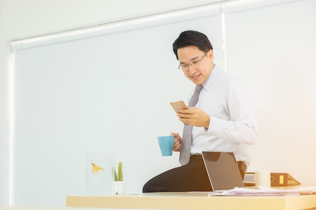 Smartphone en la mano del hombre de negocios durante la pausa del café que comprueba el correo electrónico
