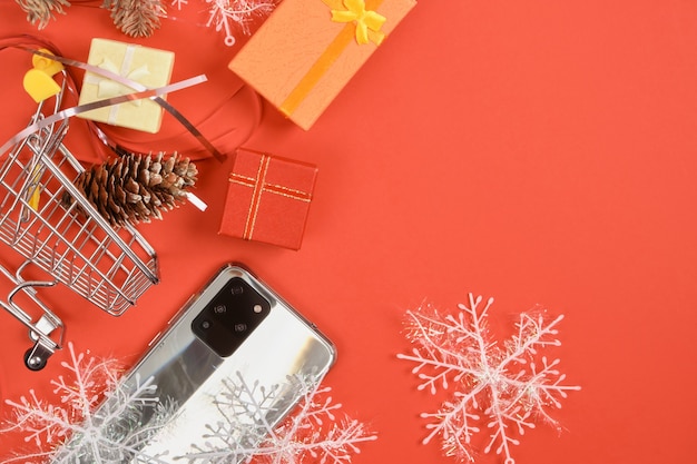 Smartphone mit drei Kameras und Weihnachtsdekor auf rotem Grund