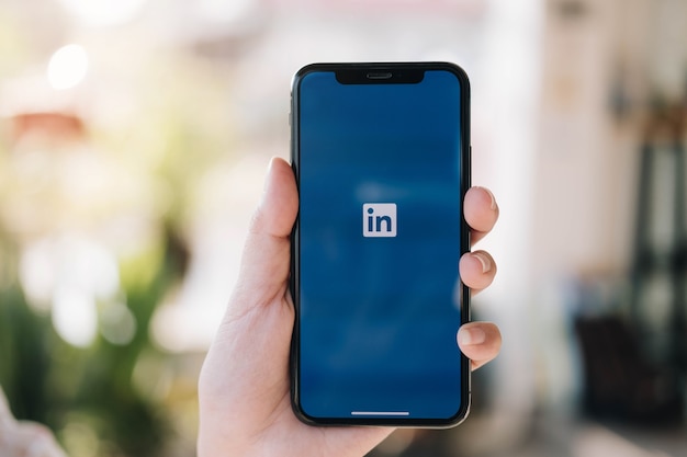 Smartphone mit LinkedIn-Anwendung auf dem Bildschirm. LinkedIn ist ein geschäftsorientierter sozialer Netzwerkdienst.