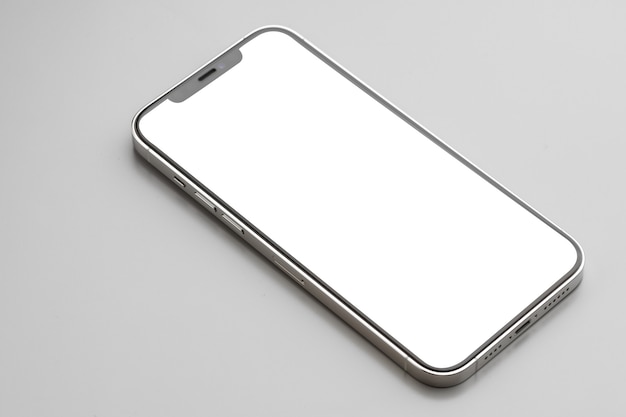 Smartphone moderno con pantalla blanca sobre superficie gris