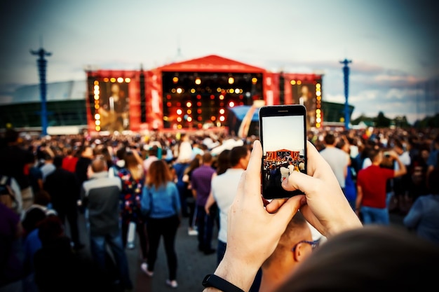 Smartphone na mão fotografando no festival de música de verão