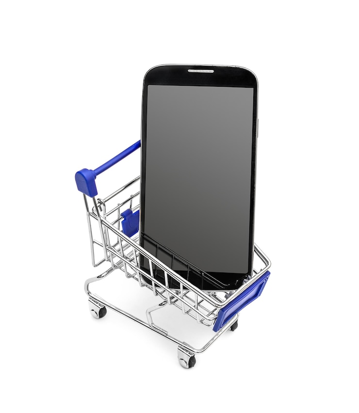 Foto smartphone con pantalla en blanco en el carrito de compras sobre fondo blanco