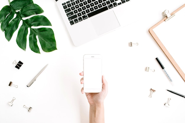 Smartphone con pantalla en blanco en mano femenina