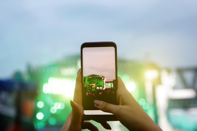 Smartphone sobre a multidão em um concerto de música. Gravar show de luzes