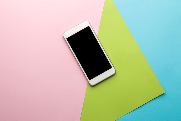 Smartphone. Weißes Telefon auf einem hellen mehrfarbigen Hintergrund. Ansicht von oben. Platz für Text