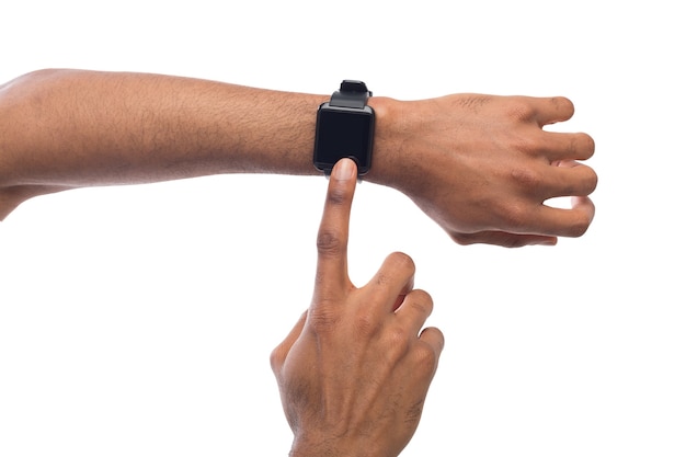 Smartwatch an schwarzer männlicher Hand, weißer Hintergrundausschnitt. Modernes digitales Gerät mit leerem Display, Kopierraum