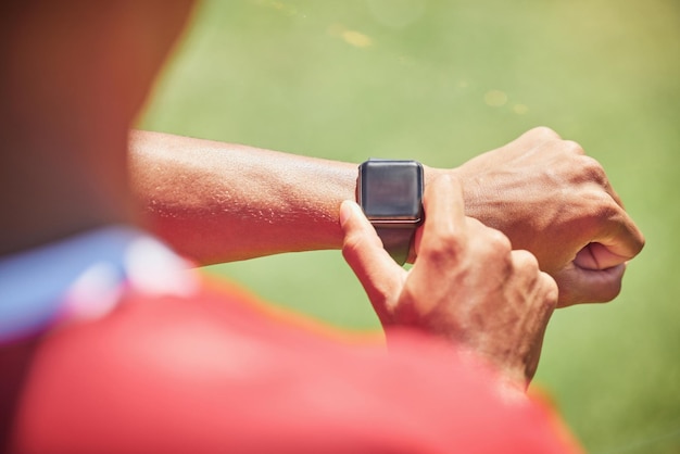 Smartwatch-Bildschirm-Mock-up und Fitness-Hände Mann überprüfen Zeit Laufergebnisse Sport- oder Trainingsfortschritt auf grünem Spielfeld Athlet auf Smartwatch für Übungsziel-Technologie mit grünem Mockup