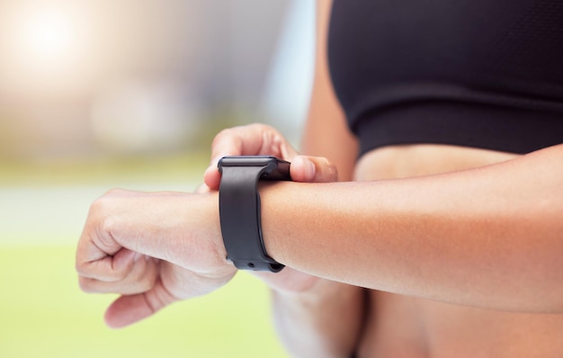 Smartwatch en manos de un corredor para rastrear las estadísticas de salud del tiempo de carrera de la mujer y entrenar para la carrera de competencia Los relojes inteligentes ayudan a motivar e inspirar al rendimiento competitivo a los atletas a mejorar el tiempo récord