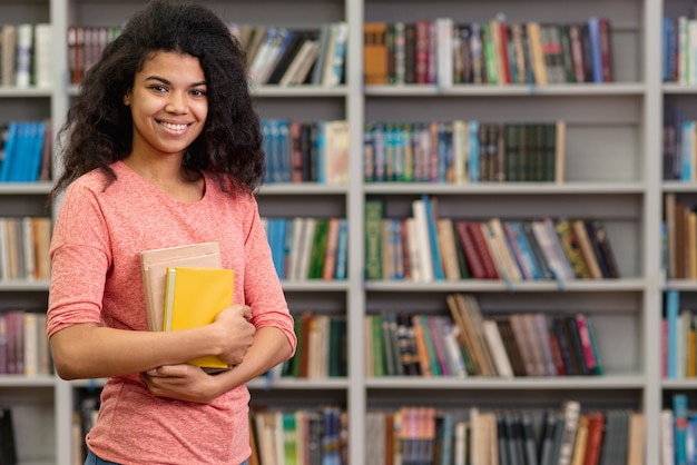 Smiley adolescente na biblioteca