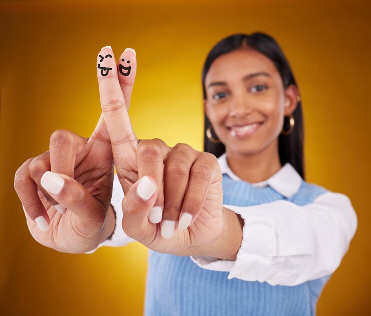 Foto smiley de dedos e retrato de mulher indiana em estúdio para expressão artística e diversão em fundo amarelo gradiente arte de mãos e desenho de sorriso de menina animado e contente com gesto de emoji ou sorte