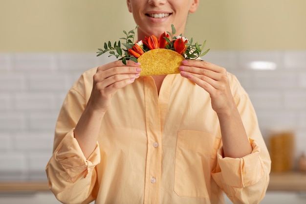 Foto smiley-erwachsener, der taco-vorderansicht hält