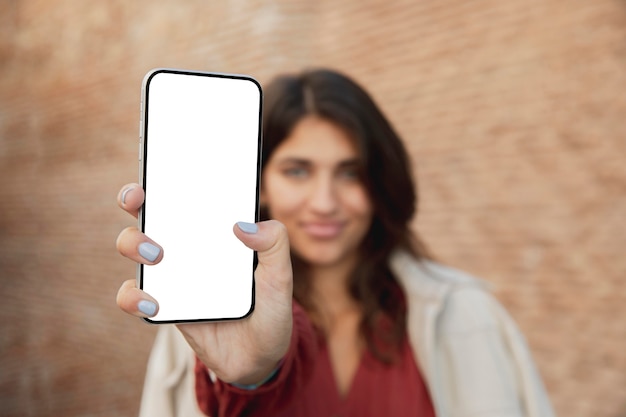 Foto smiley frau im freien hält smartphone