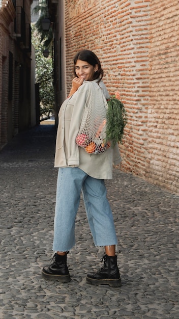 Foto smiley frau im freien mit einkaufstüten