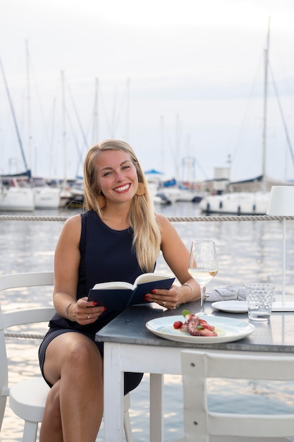 Smiley-Frau mit mittlerem Schuss, die ein Buch hält