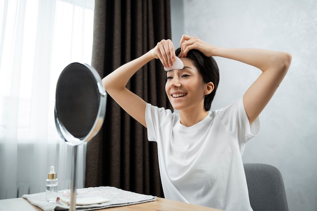 Foto smiley-frau mit mittlerem schuss, die gesicht massiert