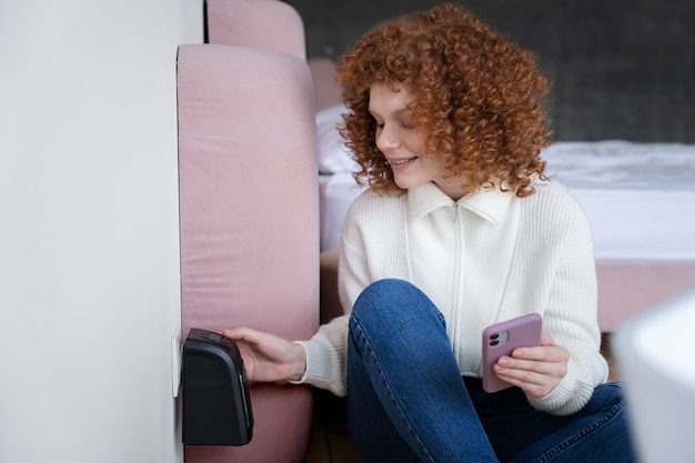 Smiley-Frau mit mittlerem Schuss, die Smartphone hält