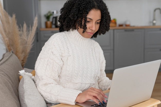 Foto smiley-frau mit mittlerem schuss und laptop