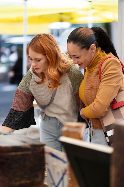 Foto smiley-frauen der seitenansicht auf dem usa-flohmarkt