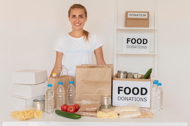 Smiley-Freiwilliger posiert mit Taschen voller Lebensmittelspenden