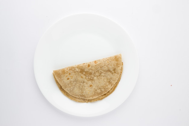 Smiley-Gesicht Lebensmittel Chapati gesundes Essen aus Weizenmehl auf weißer Keramikplatte angeordnet