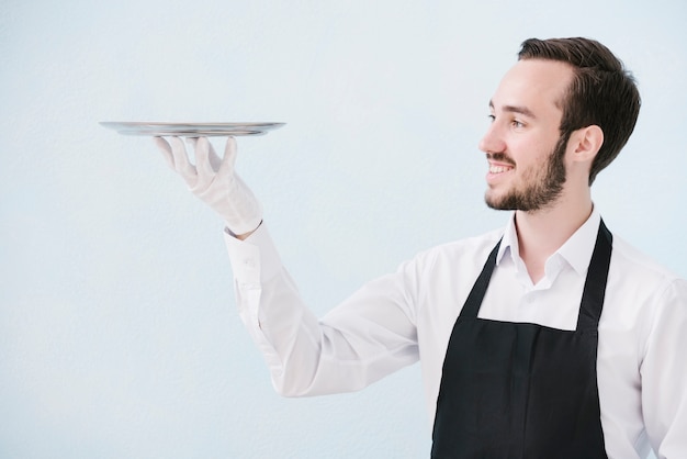 Foto smiley-kellner, der metallbehälter anhebt