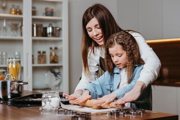 Smiley madre e hija cocinando juntos en casa