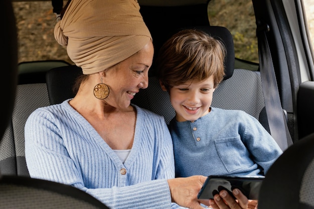 Smiley madre e hijo en coche con móvil