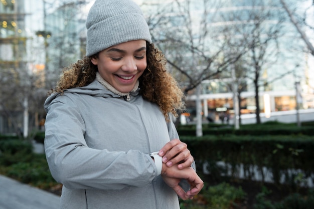 Foto smiley-mädchen mit mittlerem schuss, das die uhr überprüft