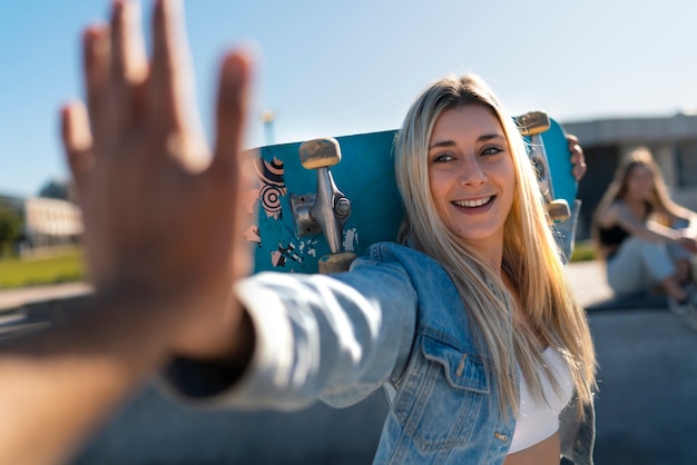 Foto smiley-mädchen mit mittlerem schuss und skateboard