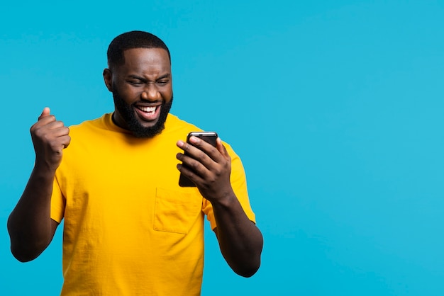 Foto smiley-mann, der handy ansieht