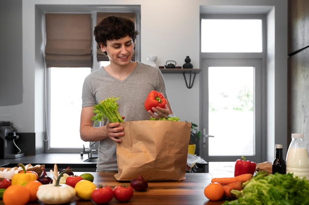 Foto smiley-mann der vorderansicht mit lebensmitteln