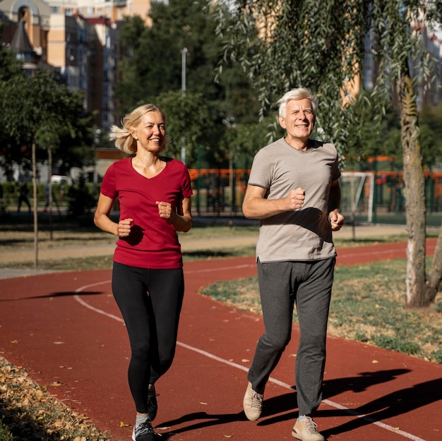 Foto smiley pareja de ancianos trotar al aire libre