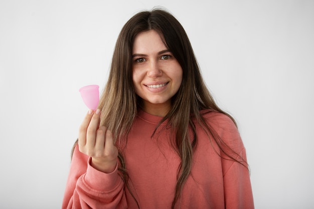 Foto smileyfrau, die vorderansicht der menstruationstasse hält