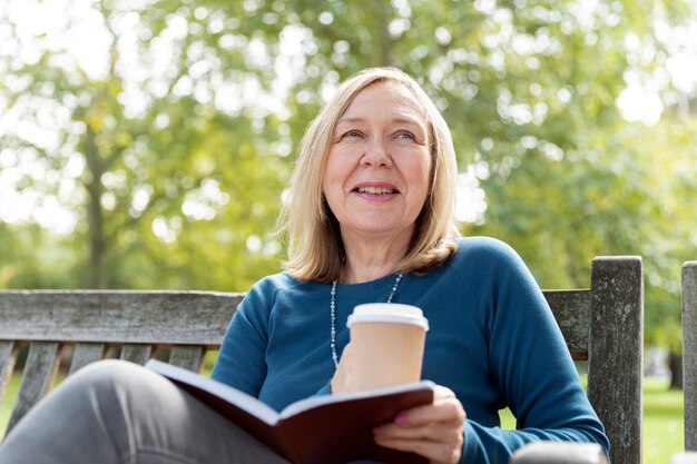 Smileyfrau mit mittlerem Schuss mit Buch