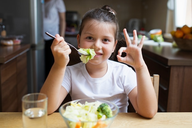 Smileymädchen, das eine heathy Mahlzeit hat