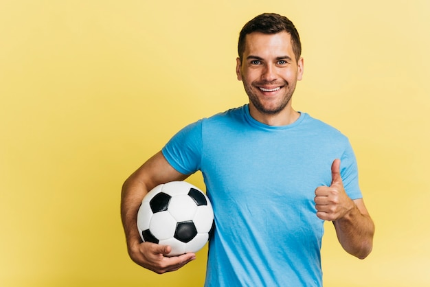 Foto smileymann, der eine fußballkugel anhält