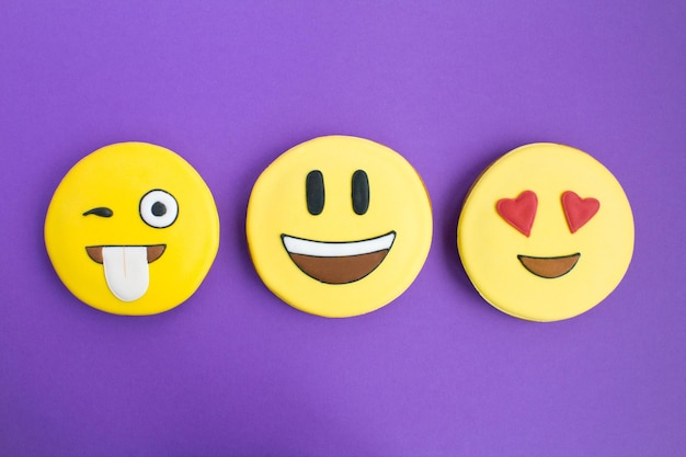 Smileys in Form von Lebkuchen auf dem violetten HintergrundDraufsichtNahaufnahmeTextfreiraum