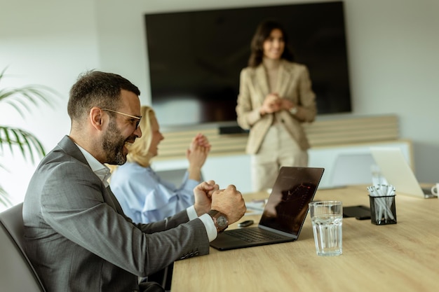 Foto smiling businessman in a modern office space enjoying a collaborative team meeting during work hours