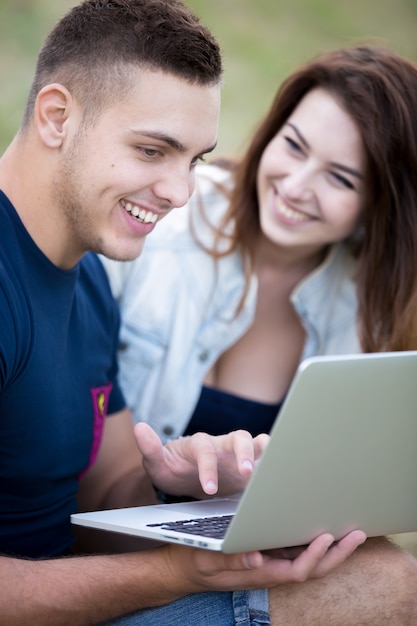 Smiling Paar schaut auf einen Laptop