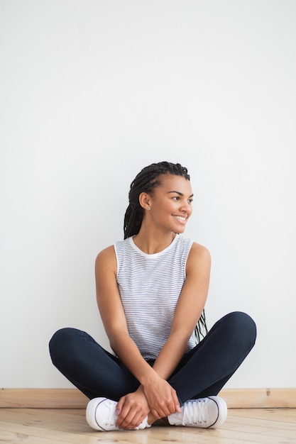 Smiling Pretty Black Woman auf dem Boden in Lotus Pose